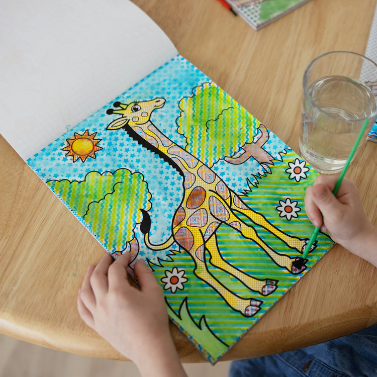 A kid playing with The Melissa & Doug My First Paint With Water Activity Books Set - Animals, Vehicles, and Pirates