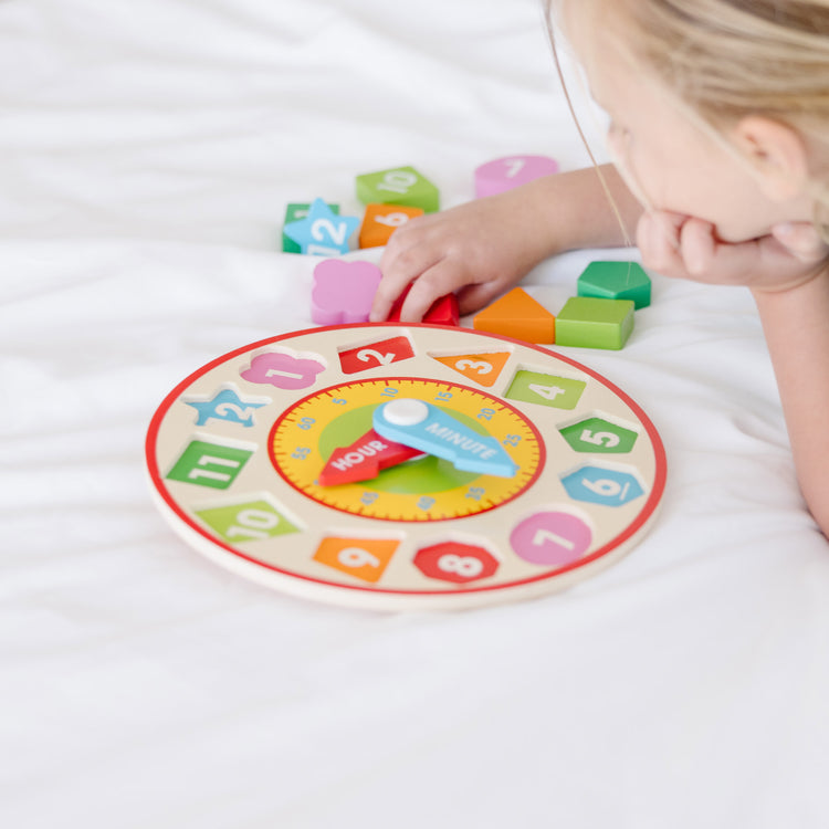 A kid playing with The Melissa & Doug Shape Sorting Clock - Wooden Educational Toy