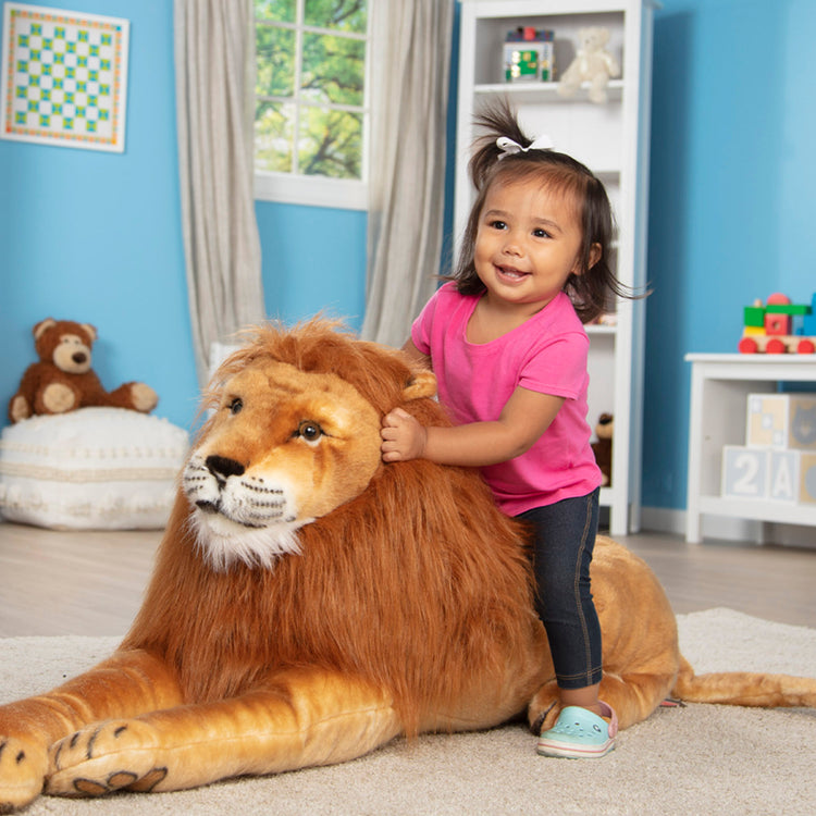 A kid playing with The Melissa & Doug Giant Lion - Lifelike Stuffed Animal (over 6 feet long)
