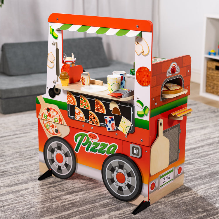 A playroom scene with The Melissa & Doug Wooden Pizza Food Truck Activity Center with Play Food, for Boys and Girls 3+