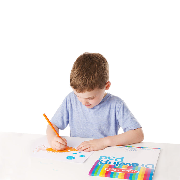 A child on white background with The Melissa & Doug Drawing Paper Pad (9 x 12 inches) - 50 Sheets, 3-Pack