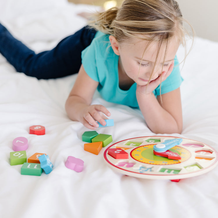 A kid playing with The Melissa & Doug Shape Sorting Clock - Wooden Educational Toy