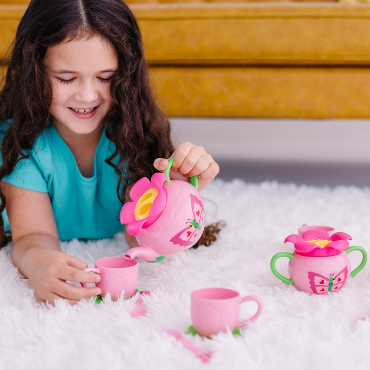 A kid playing with The Melissa & Doug Butterfly Tea Set (15 pcs) - Play Food Accessories