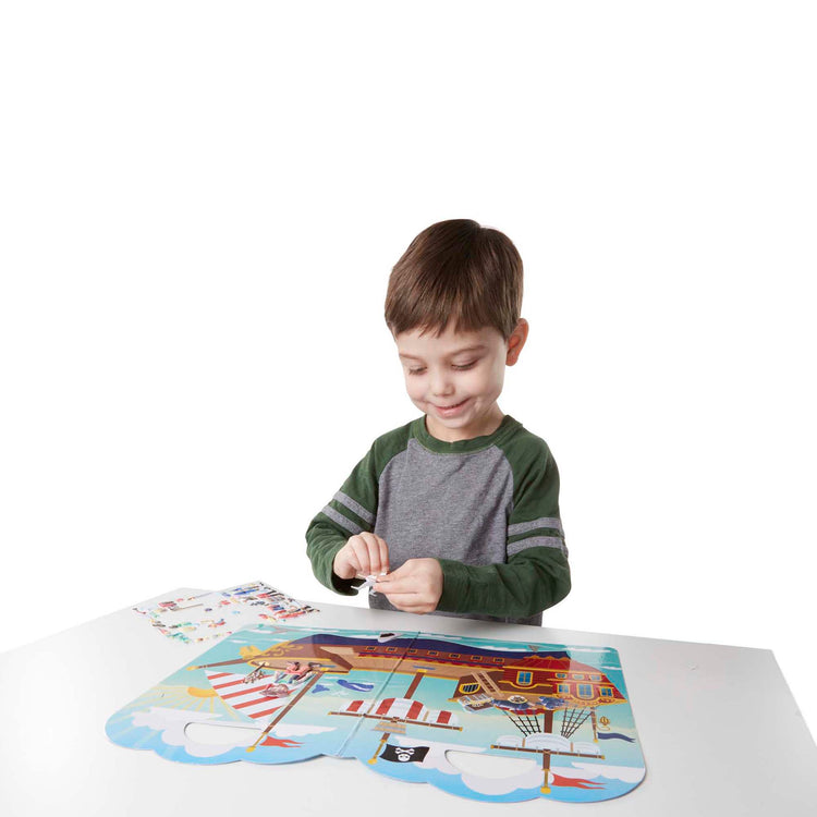 A child on white background with The Melissa & Doug Puffy Sticker Activity Book: Pirates - 51 Reusable Stickers