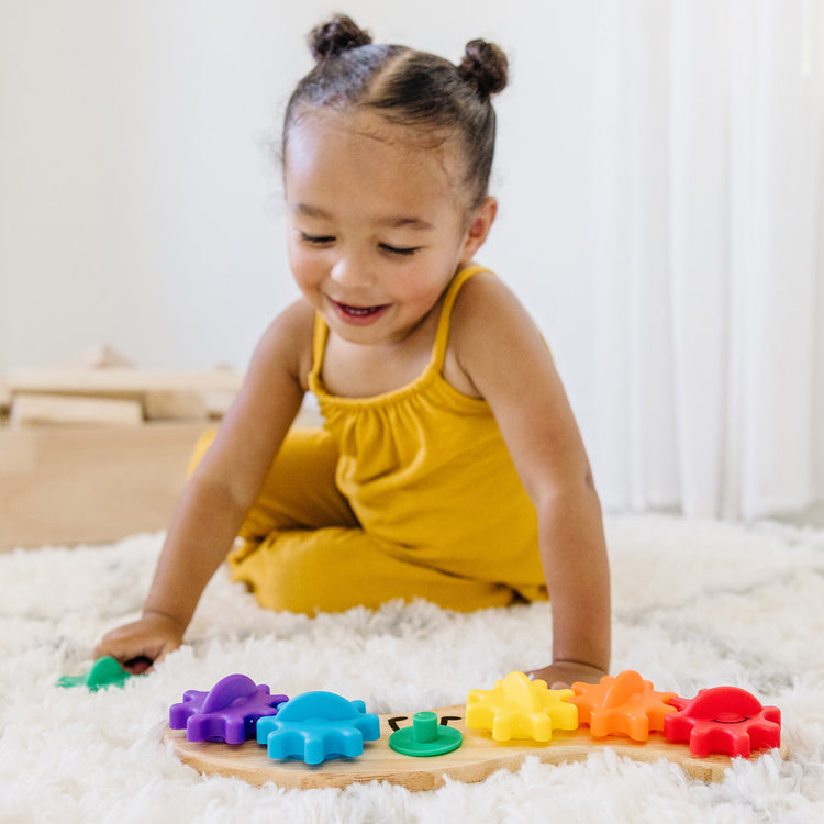 A kid playing with The Melissa & Doug 4 Wooden Classic Rainbow Learning Toys