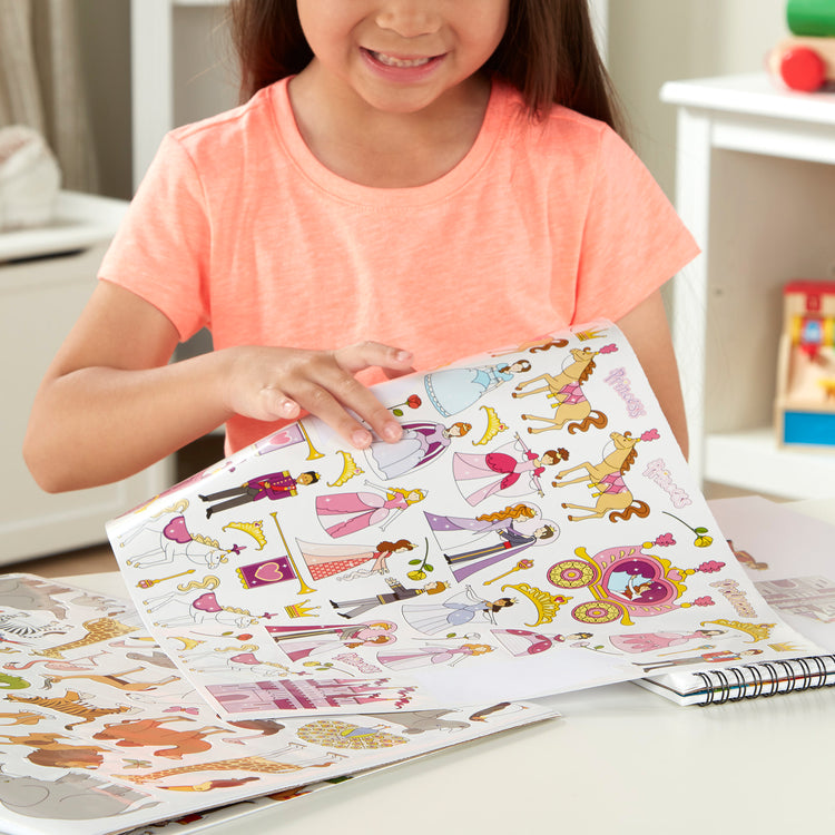 A kid playing with The Melissa & Doug Sticker Collection Book: Princesses, Tea Party, Animals, and More - 500+ Stickers