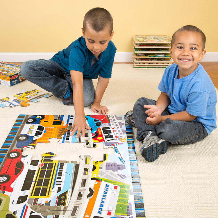 A kid playing with The Melissa & Doug Traffic Jam Jumbo Jigsaw Floor Puzzle (24 pcs, 2 x 3 feet long)