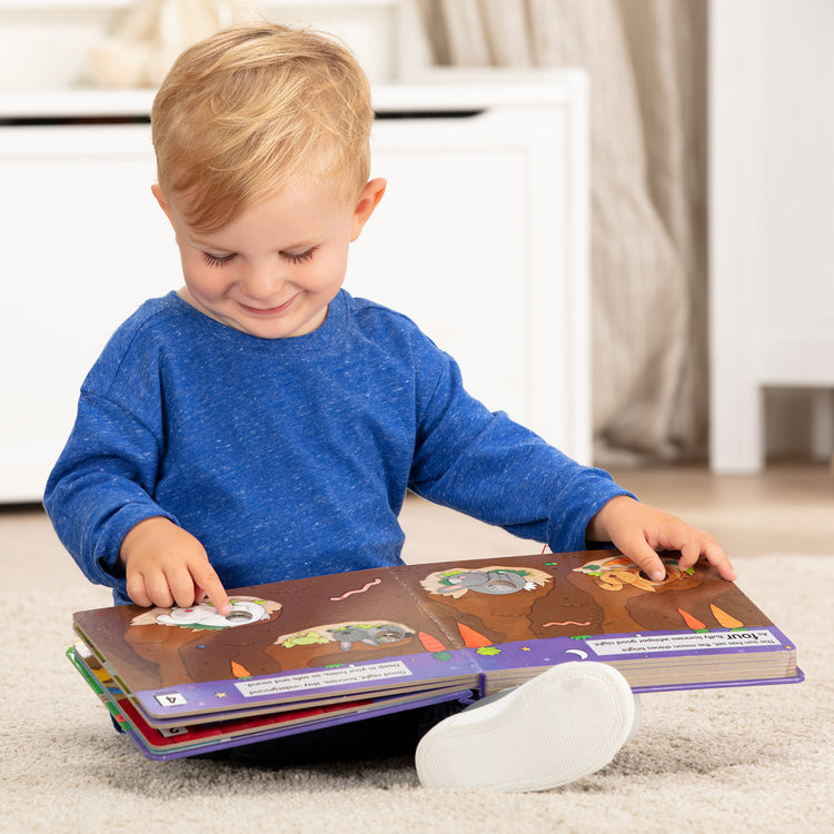A kid playing with The Melissa & Doug Children's Book - Poke-a-Dot: Goodnight, Animals (Board Book with Buttons to Pop)