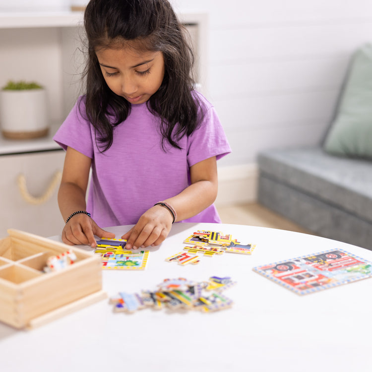 A kid playing with The Melissa & Doug Vehicles 4-in-1 Wooden Jigsaw Puzzles in a Storage Box (48 pcs)
