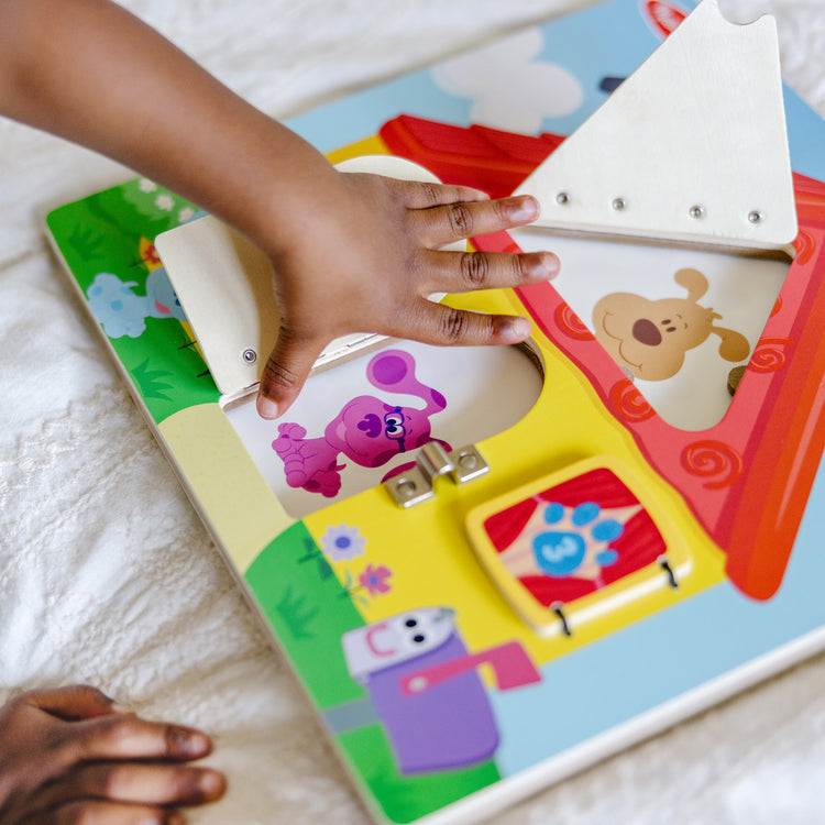 A kid playing with The Melissa & Doug Blue’s Clues & You! Wooden Activity Board with Clue Cards