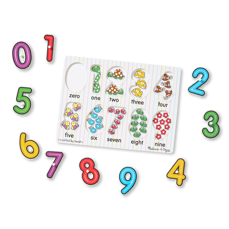 The loose pieces of The Melissa & Doug Lift & See Numbers Wooden Peg Puzzle - 10 Pieces