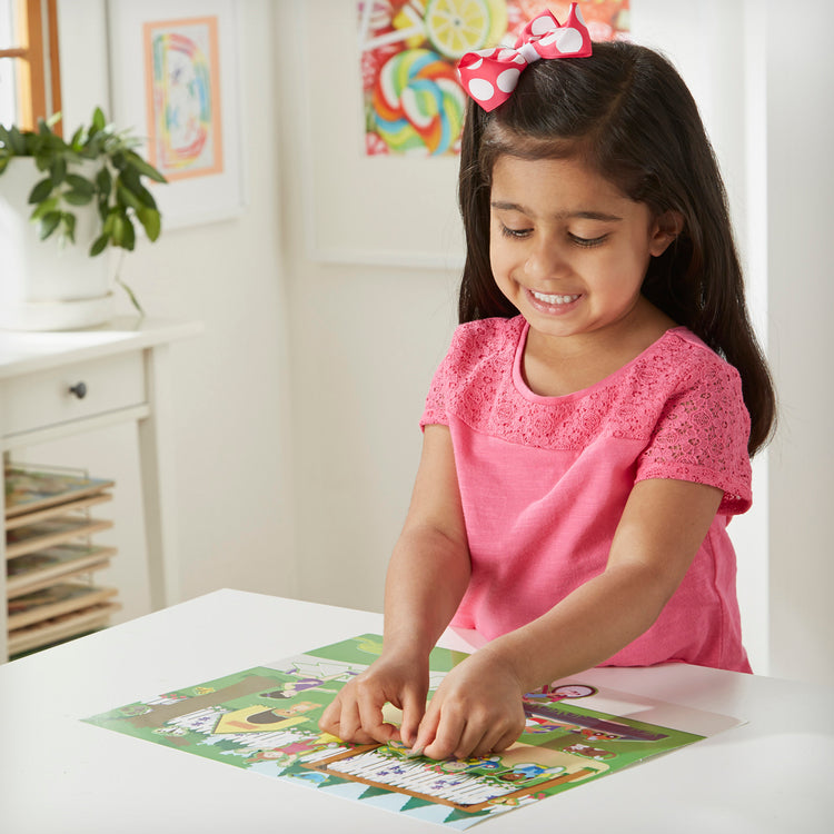 A kid playing with The Melissa & Doug Reusable Sticker Pad Set: Play House - 175+ Reusable Stickers