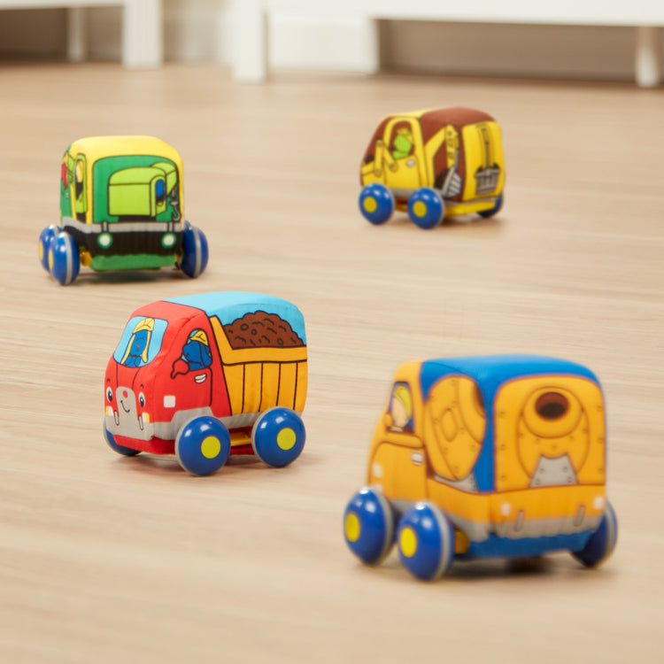 The loose pieces of The Melissa & Doug Pull-Back Construction Vehicles - Soft Baby Toy Play Set of 4 Vehicles