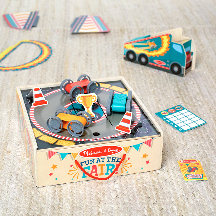 A playroom scene with The Melissa & Doug Fun at the Fair! Wooden Ring of Fire Stunt Jumper Cars Game