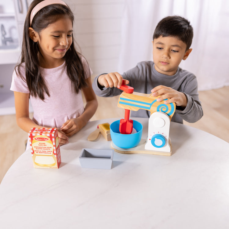 A kid playing with The Melissa & Doug Wooden Make-a-Cake Mixer Set (11 pcs) - Play Food and Kitchen Accessories