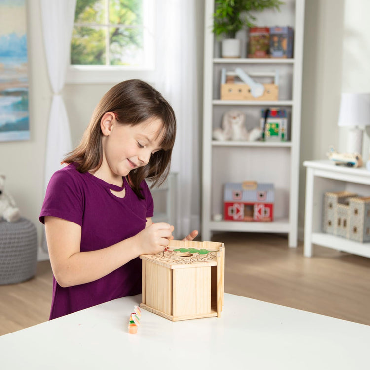 A kid playing with the Melissa & Doug Created by Me! Birdhouse Build-Your-Own Wooden Craft Kit