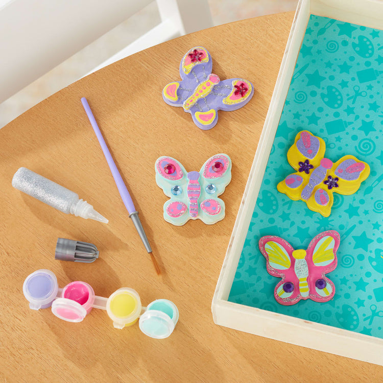 the Melissa & Doug Created by Me! Wooden Butterfly Magnets Craft Kit (4 Designs, 4 Paints, Stickers, Glitter Glue)