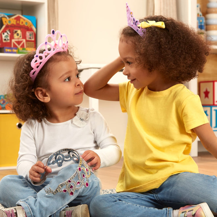 A kid playing with the Melissa & Doug Dress-Up Tiaras for Costume Role Play (4 pcs)