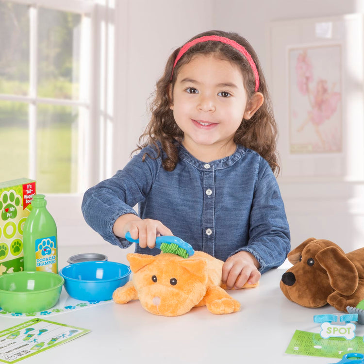 A kid playing with the Melissa & Doug Feeding and Grooming Pet Care Play Set
