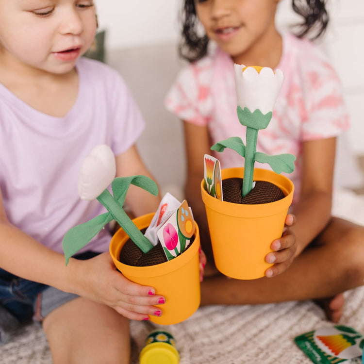 A kid playing with the Melissa & Doug Let’s Explore Flower Gardening Play Set with Color-Changing Flowers (16 Pieces)