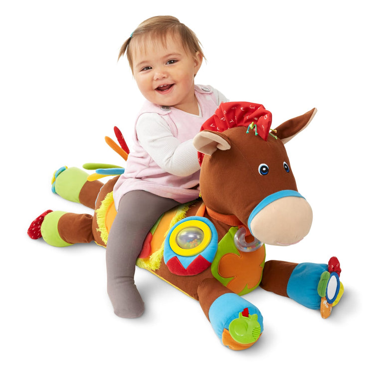 A child on white background with the Melissa & Doug Giddy-Up and Play Baby Activity Toy - Multi-Sensory Horse