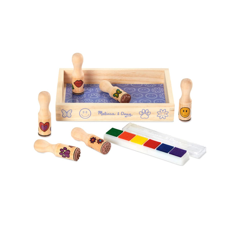 The loose pieces of the Melissa & Doug Happy Handles Wooden Stamp Set: 6 Stamps and 6-Color Stamp Pad