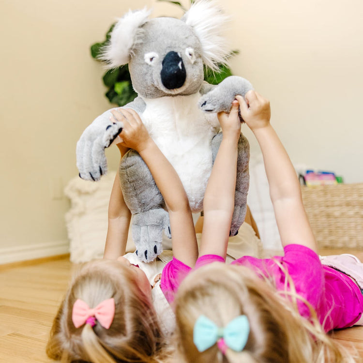 A kid playing with the Melissa & Doug Lifelike Plush Koala Stuffed Animal (13.5W x 14H x 12D in)