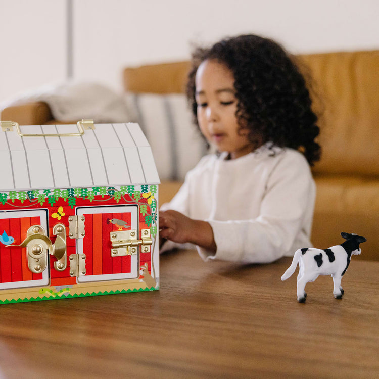 A kid playing with the Melissa & Doug Latches Wooden Activity Barn with 6 Doors, 4 Play Figure Farm Animals