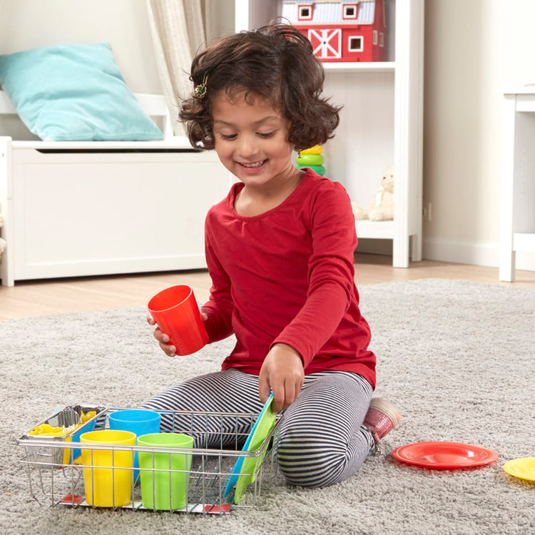 A kid playing with the Melissa & Doug Wash and Dry Dish Set - 24 Pieces