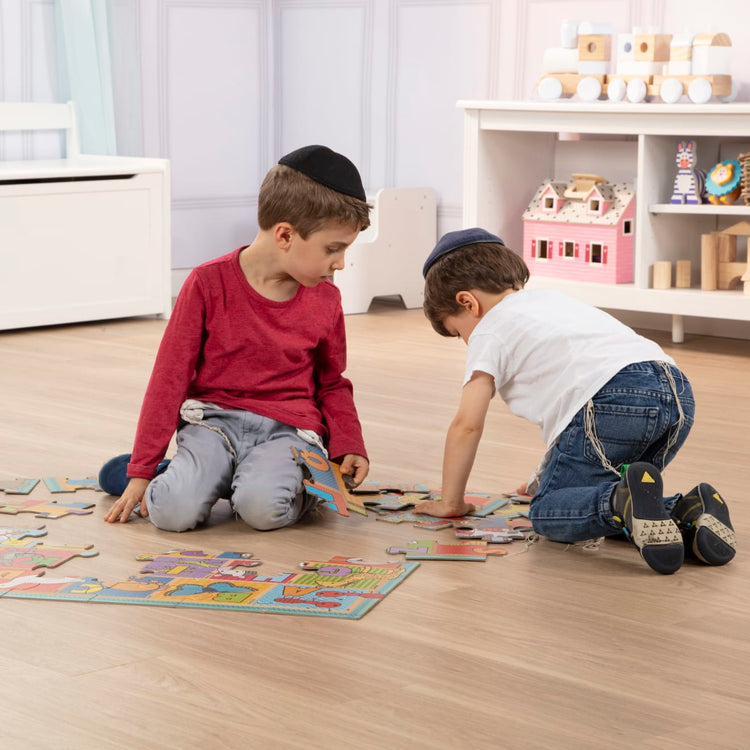 A kid playing with the Melissa & Doug Natural Play Giant Floor Puzzle: ABC Animals (35 Pieces)