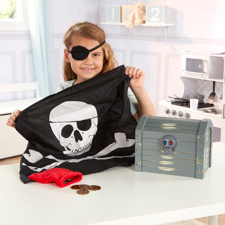 A kid playing with the Melissa & Doug Wooden Pirate Chest Pretend Play Set