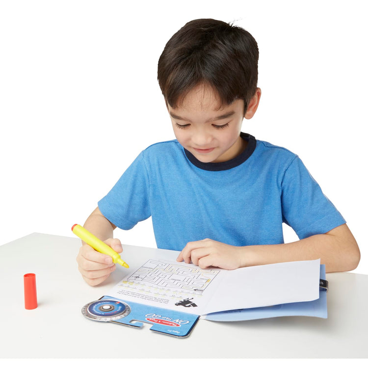 A child on white background with the Melissa & Doug On the Go Spy Mystery Secret Decoder Book With Decoder Wheel and Magic-Reveal Pen