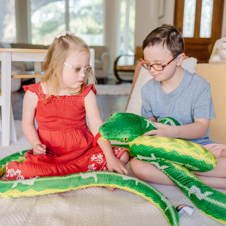 A kid playing with the Melissa & Doug Giant Boa Constrictor - Lifelike Stuffed Animal Snake (over 14 feet long)