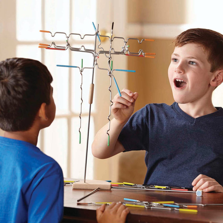 A kid playing with the Melissa & Doug Suspend Family Game (31 pcs)