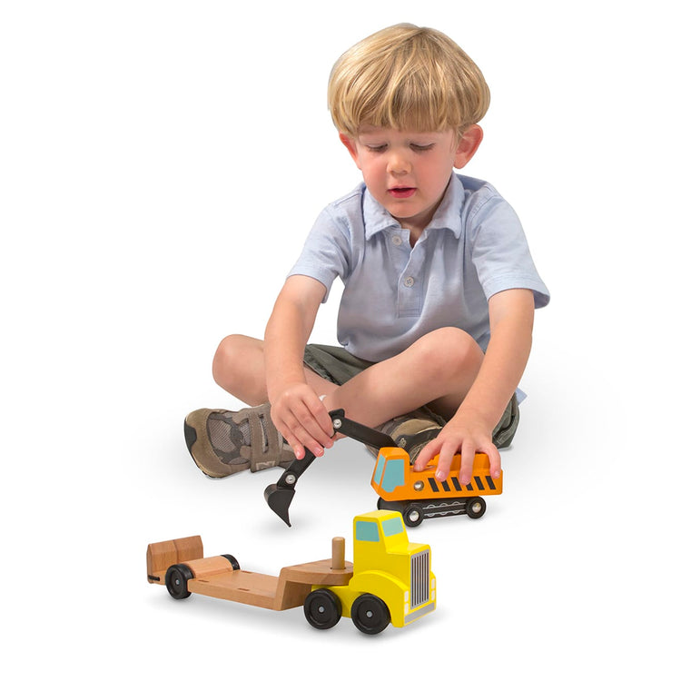 A child on white background with the Melissa & Doug Trailer and Excavator Wooden Vehicle Set (3 pcs)