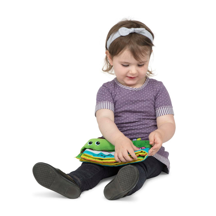 A child on white background with the Melissa & Doug Soft Activity Baby Book - Whose Feet?