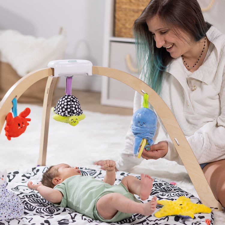 Melissa & Doug Our Best Baby Shower Gifts blog post mom with baby in play gym