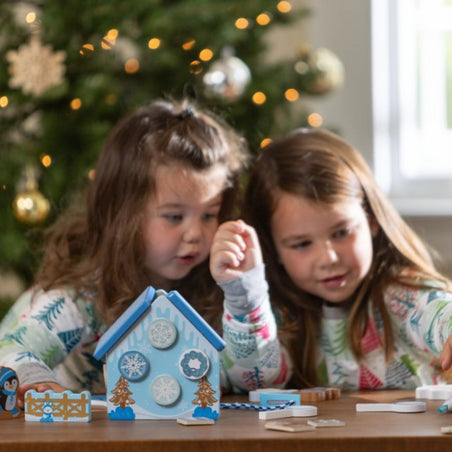 Melissa & Doug Our Best Toys for Holiday Travel blog post kids playing Wooden Gingerbread House