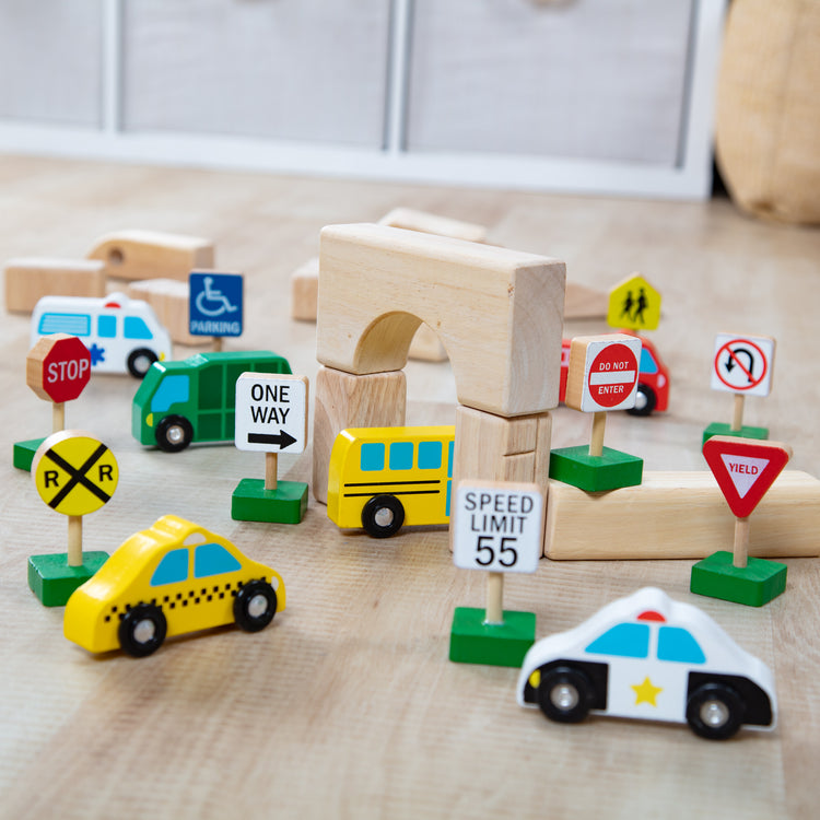 A playroom scene with The Melissa & Doug Wooden Vehicles and Traffic Signs With 6 Cars and 9 Signs