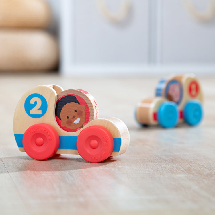 A playroom scene with The Melissa & Doug GO Tots Wooden Race Cars (2 Cars, 2 Disks)