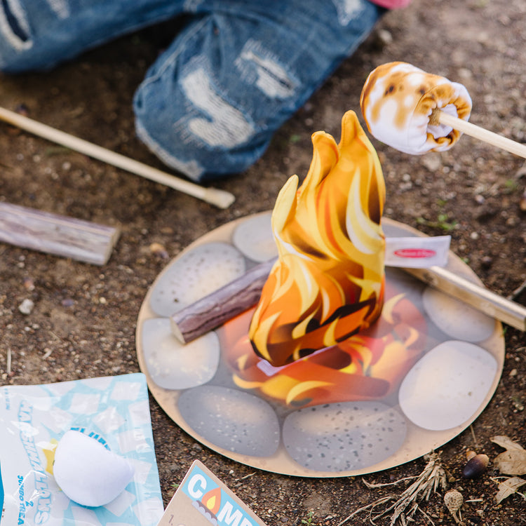 A kid playing with The Melissa & Doug Let's Explore Campfire S'Mores Play Set