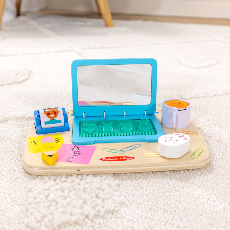 A playroom scene with The Melissa & Doug Wooden Work & Play Desktop Activity Board Infant and Toddler Sensory Toy