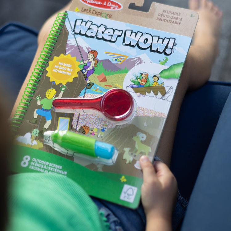 A kid playing with The Melissa & Doug Let’s Explore Water Wow! Outdoor Adventure Deluxe Water-Reveal Pad – Reusable On The Go Travel Activity