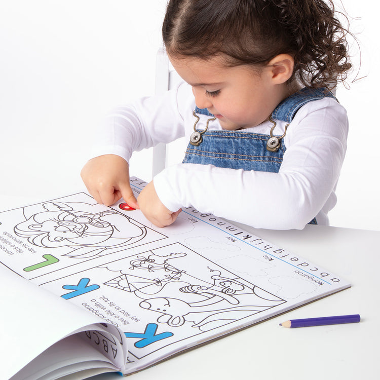 A child on white background with The Melissa & Doug Alphabet Activity Sticker Pad for Coloring, Letters (250+ Stickers)
