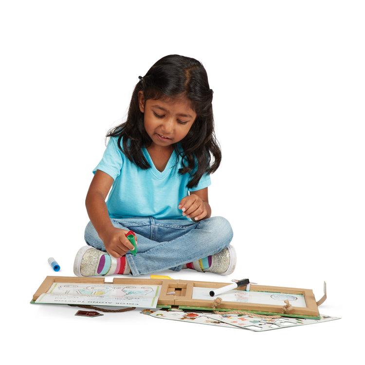 A child on white background with The Melissa & Doug Natural Play: Play, Draw, Create Reusable Drawing & Magnet Kit – Farm (38 Magnets, 5 Dry-Erase Markers)