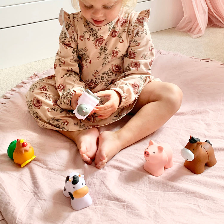 A kid playing with The Melissa & Doug Pop Blocs Farm Animals Educational Baby Toy - 10 Linkable Pieces