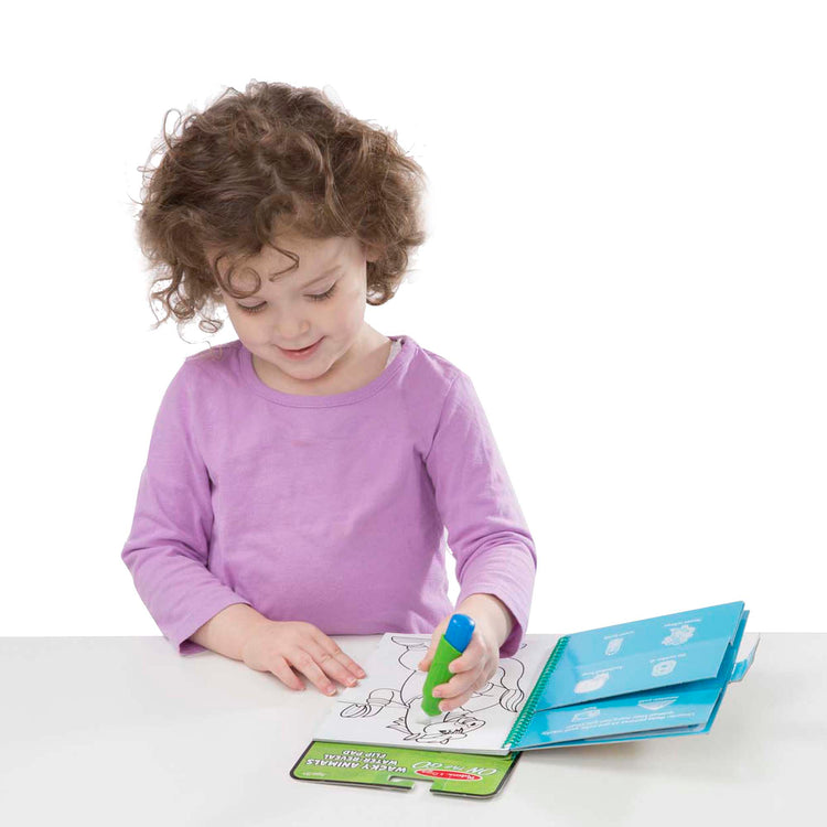 A child on white background with The Melissa & Doug On the Go Water Wow! Reusable Water-Reveal Flip Pad - Wacky Animals
