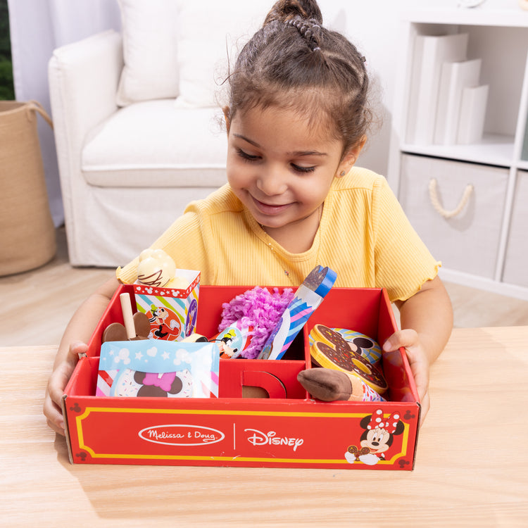 A kid playing with The Melissa & Doug Disney Snacks & Popcorn Wooden Play Food Set – 24 Pieces | Mickey Mouse, Minnie, Wooden Toy for Boys and for Girls 3+