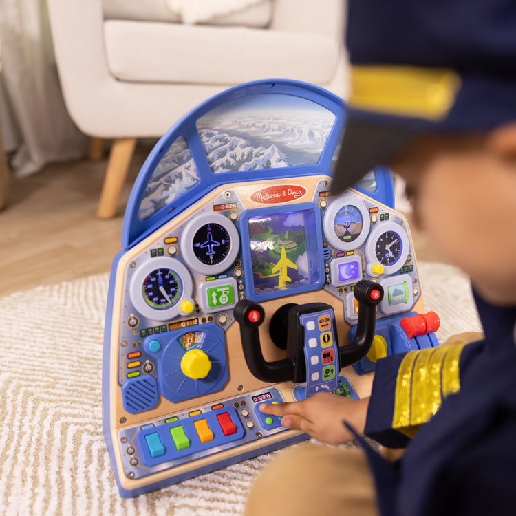 A kid playing with The Melissa & Doug Jet Pilot Interactive Dashboard Wooden Toy for Boys and Girls Ages 3+