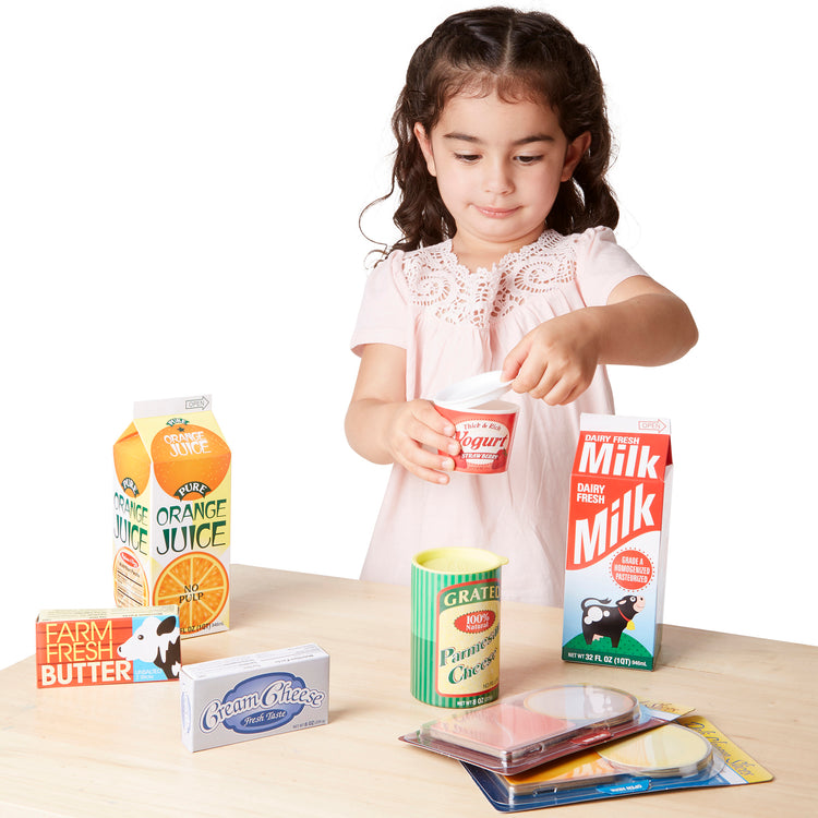 A child on white background with The Melissa & Doug Fridge Groceries Play Food Cartons (8 pieces)